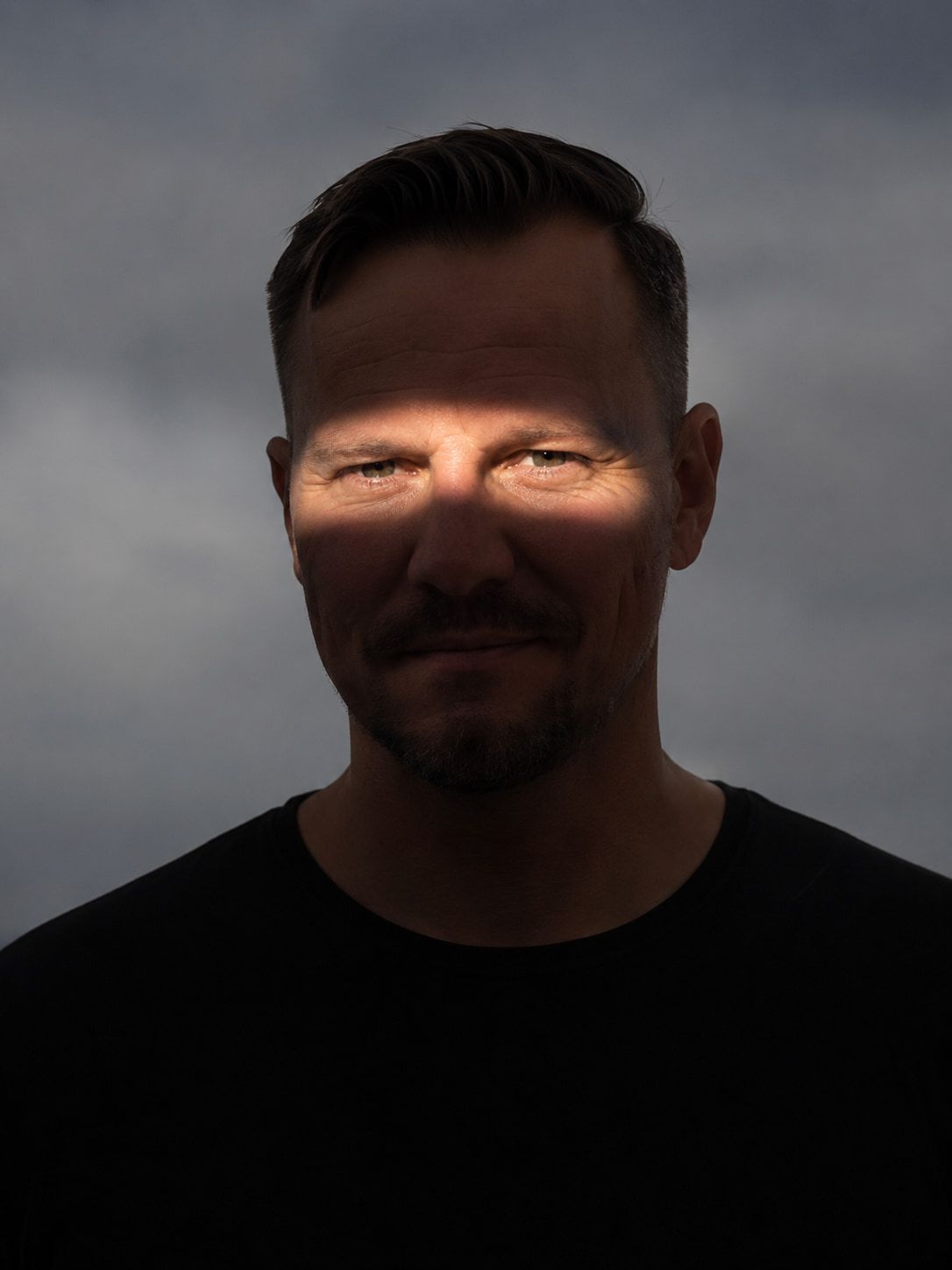 Nahes Portrait von Jan Rolfsmeyer bei wenig Licht, nur die Augenpartie ist beleuchtet.